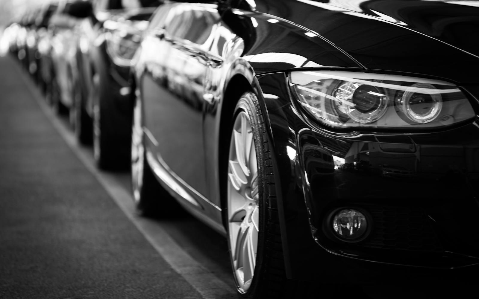 black and white photo of cars parked on the street